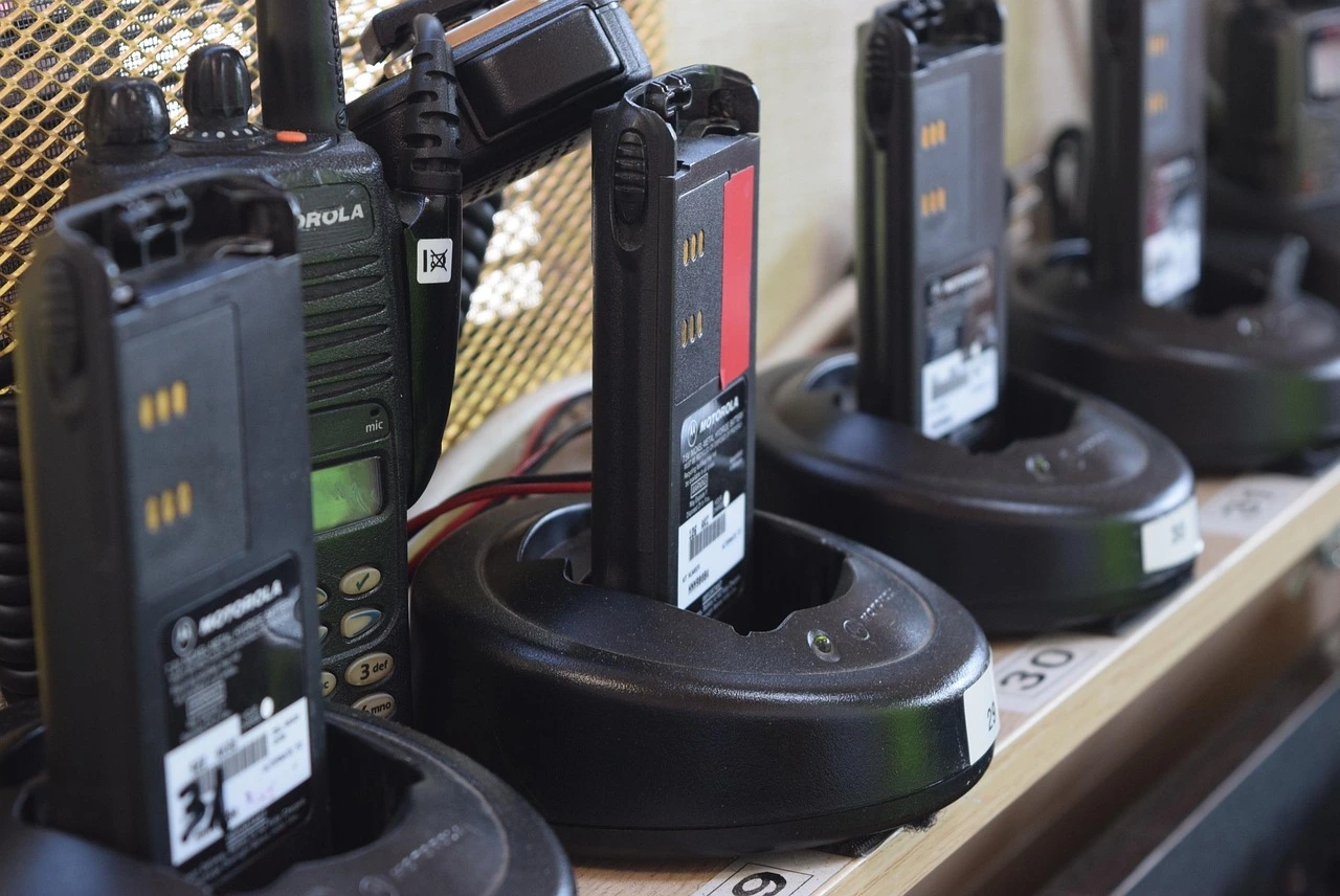 a group of black electronic walkies in a charging station