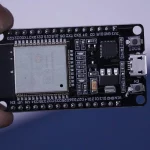 a hand holding a black circuit board