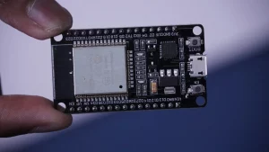 a hand holding a black circuit board