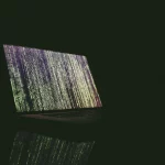 Portatil infectado encima de una mesa en ambiente oscuro