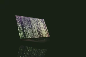 Portatil infectado encima de una mesa en ambiente oscuro